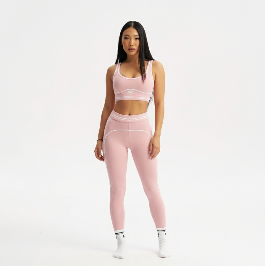 Woman wearing a pink athletic outfit on a white background