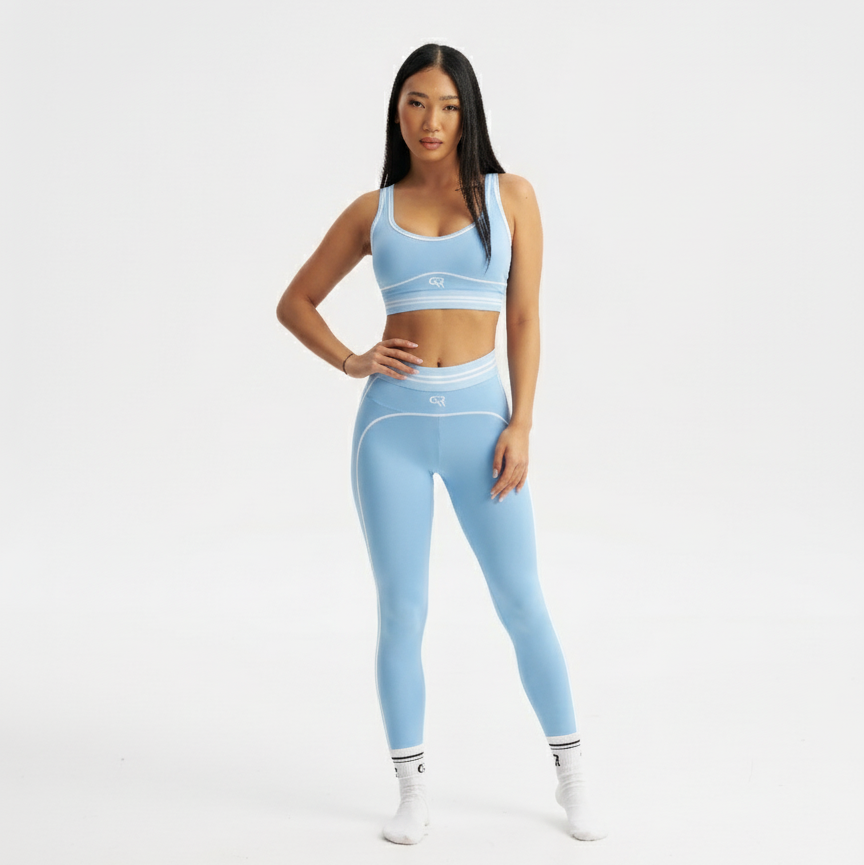 Woman wearing a light blue athletic outfit on a white background