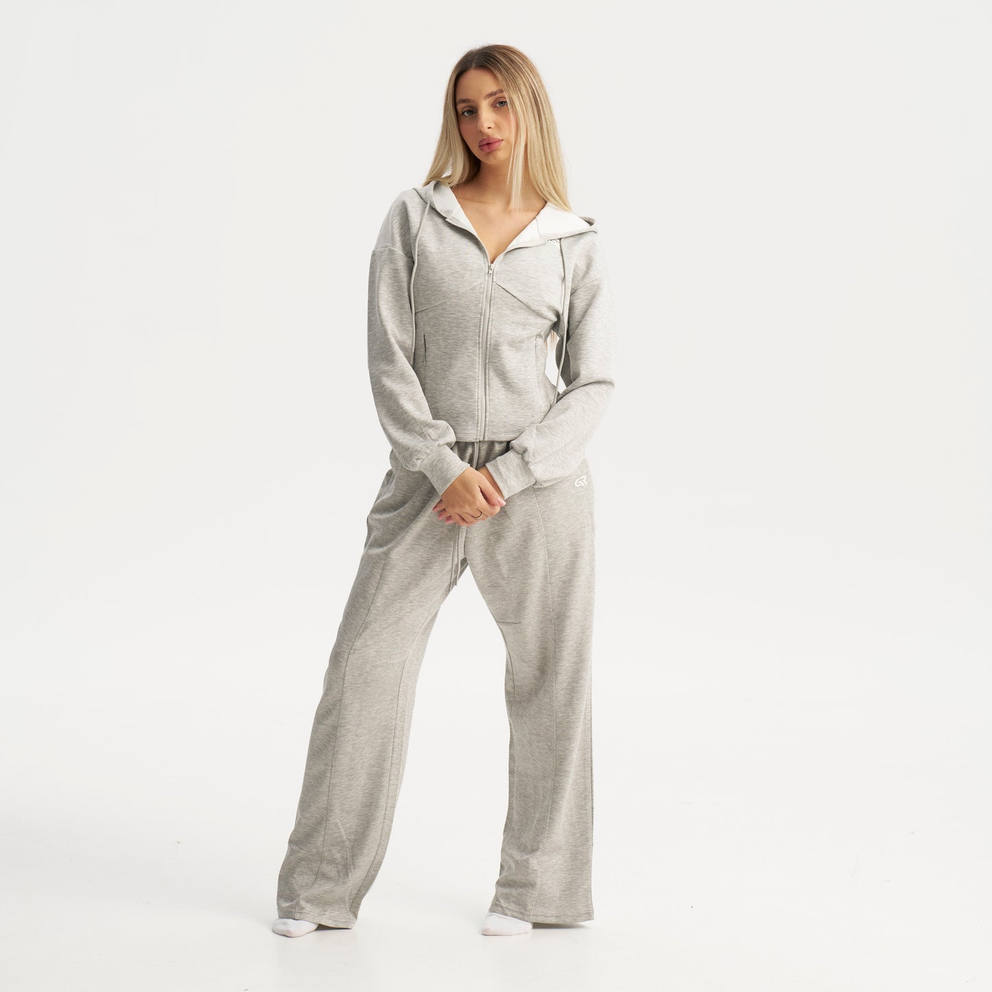 Woman wearing a gray tracksuit on a white background