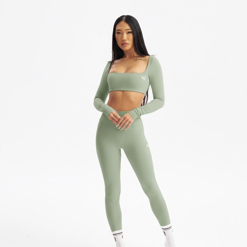 Woman wearing a green athletic outfit on a white background