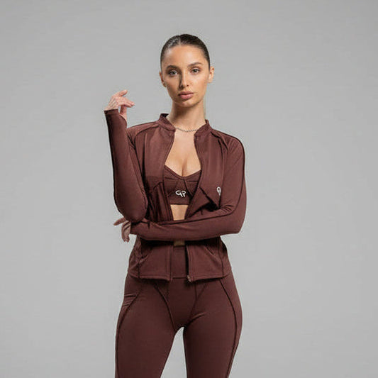 Woman wearing a brown athletic outfit on a gray background